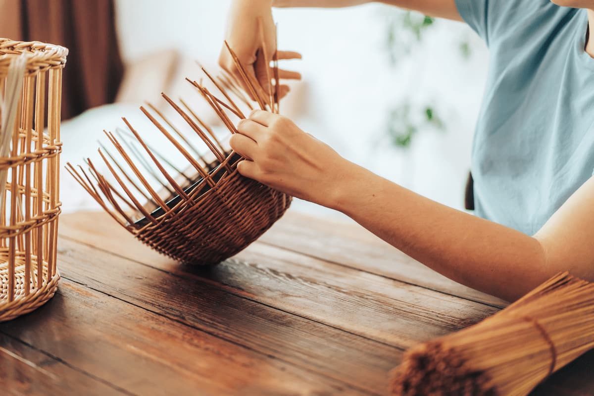 woman weaves basket of paper tubes on wooden table 2025 02 12 05 40 46 utc 1 MimPlas